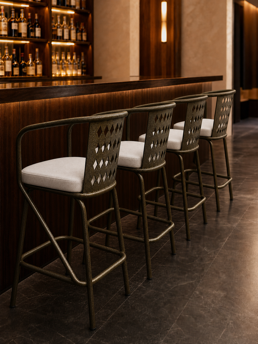 Four fabricated metal bar stools facing a refined hospitality bar counter